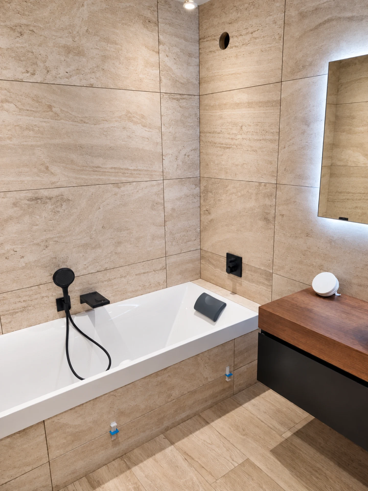 Salle de bain rénovée avec baignoire habillée et carrelage grand format effet pierre