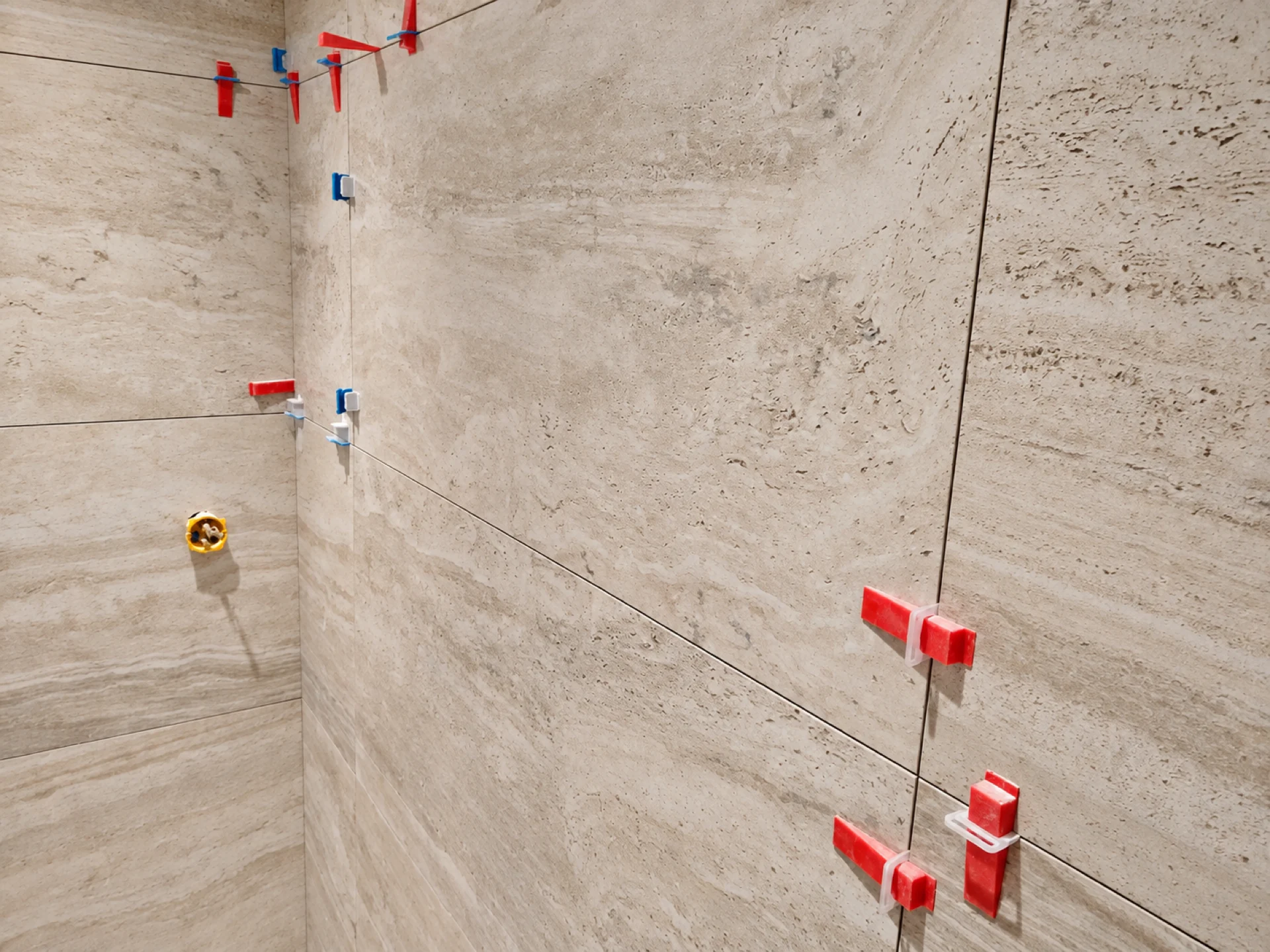 Pose de carrelage mural grand format avec croisillons de nivellement